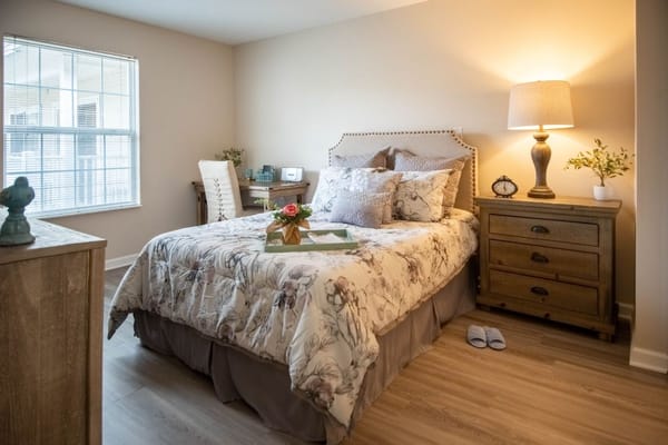 Comfortable bedroom with floral bedding and a warm lamp