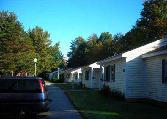 Pathway lined with residents' apartments surrounded by trees