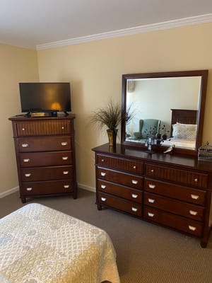 Well-furnished resident room with a television and dresser