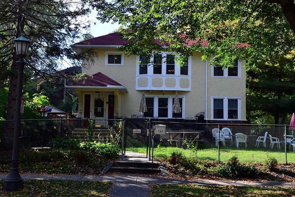View of the Rakhma Joy Home with front porch and lawn seating.