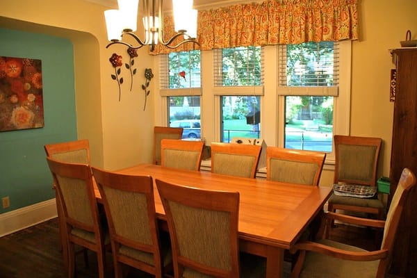 Wooden dining table with chairs in a well-lit room