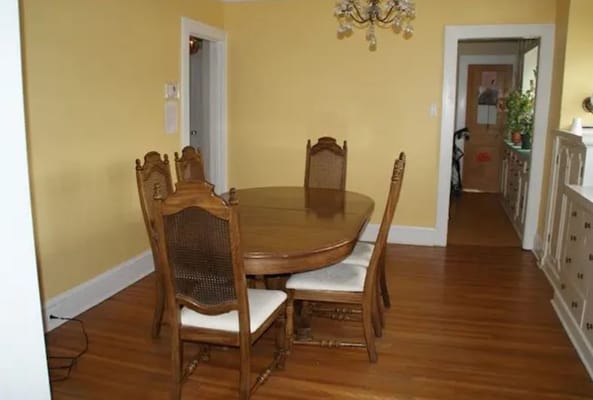 Wooden dining table with chairs in a yellow room