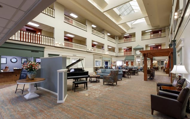 Spacious lobby with seating and a piano at Rivermont Independent Living.
