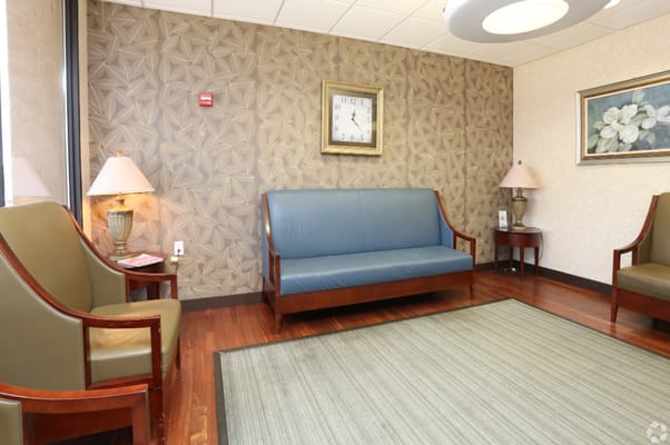 Cozy lobby seating area with lamps and decorative wall.