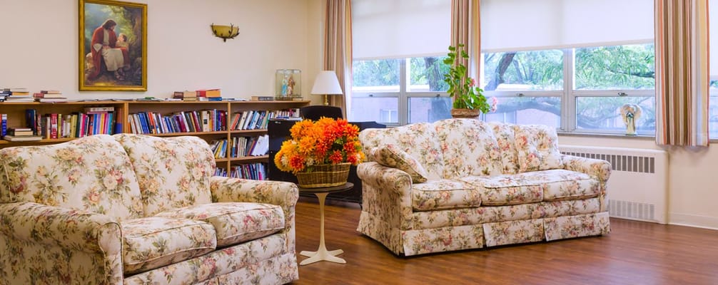 Cozy common area with floral couches and bookshelves
