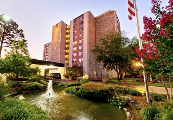 Exterior view of a senior living facility with gardens