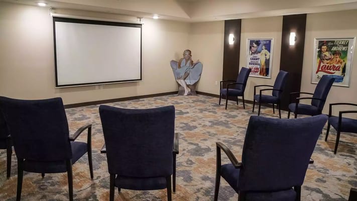 Interior of a common area with chairs and a screen