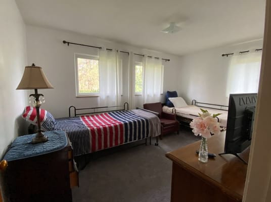 Cozy shared bedroom with two beds and natural light.