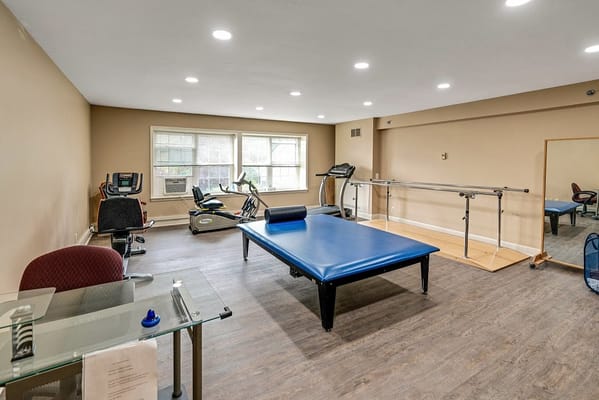 Interior view of the fitness room featuring exercise equipment and physical therapy area.