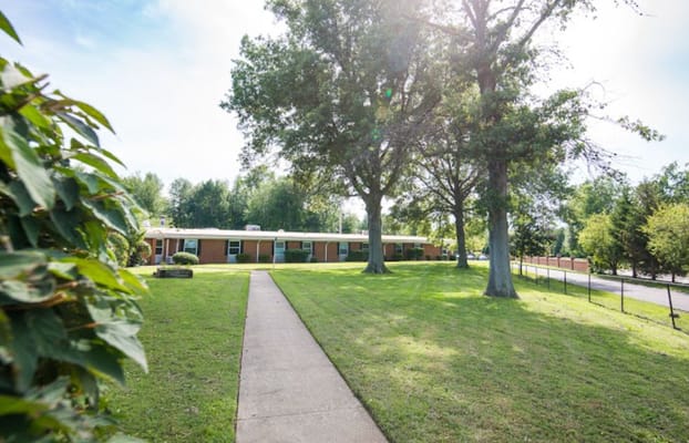 Pathway leading to the entrance of the facility surrounded by greenery