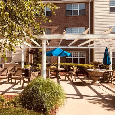 Outdoor seating area with blue umbrellas and lush greenery