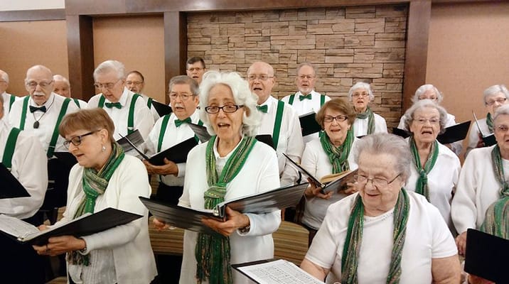 A senior choir performing with sheet music in hand