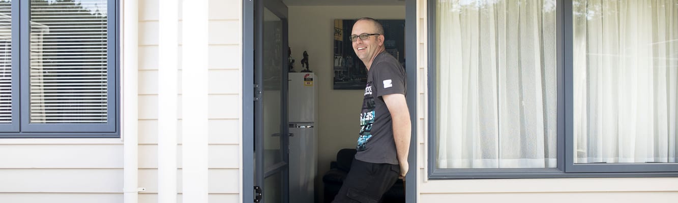 Resident smiling at the entrance of their room