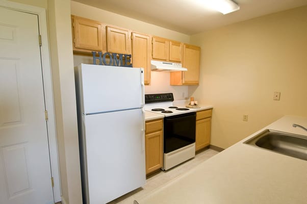 Spacious kitchen with white appliances and wooden cabinets