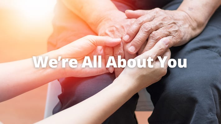 Two hands holding each other to convey support and care.