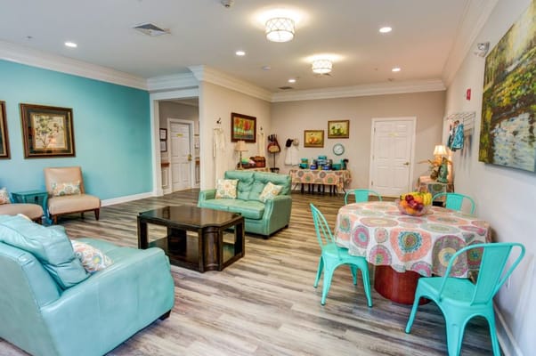 Bright and welcoming common area with teal seating and colorful decor