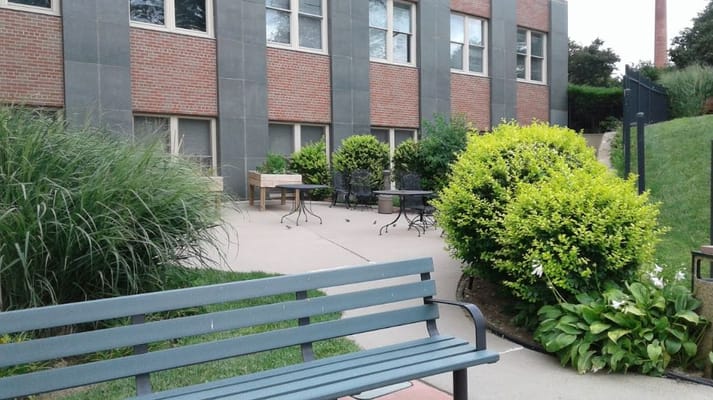 Outdoor seating area with benches and greenery