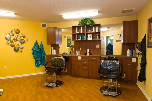 Interior of a hair salon with two chairs and a styling station