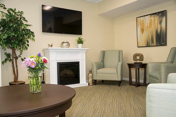 Lounge area featuring a fireplace, comfortable seating, and a floral arrangement.