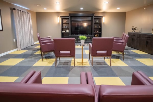 Comfortable seating area with maroon chairs and a television