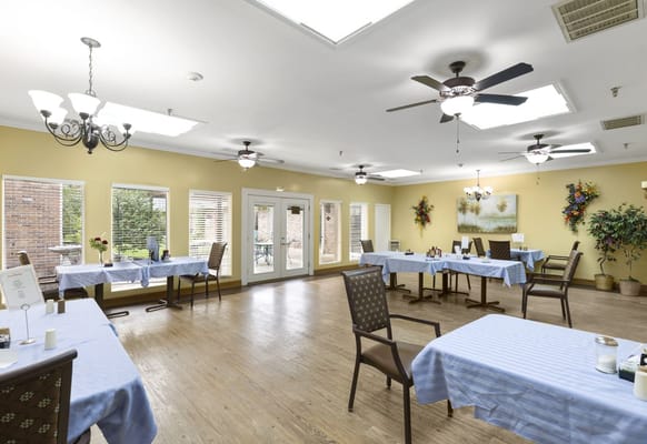 Dining area setup with blue tablecloths and natural light