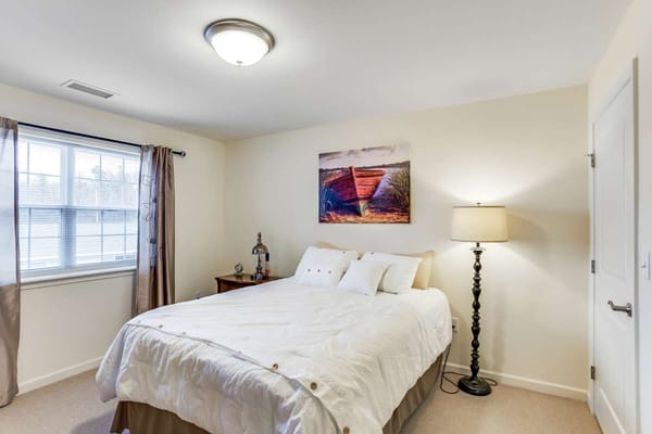 Comfortable bedroom with a bed, lamp, and artwork