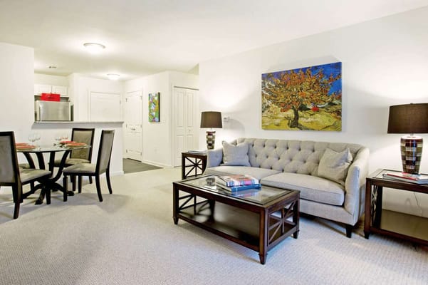 A beautifully decorated living room featuring a couch, coffee table, and art on the wall.