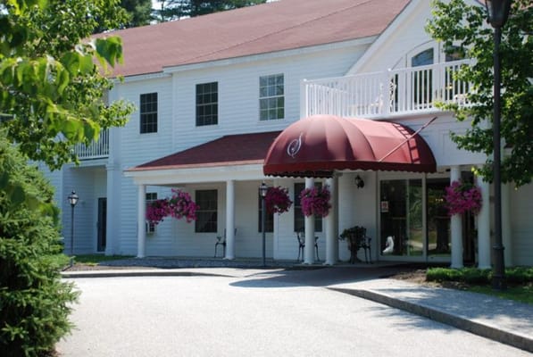 Entrance with red awning and hanging flowers at Sunnybrook Senior Living