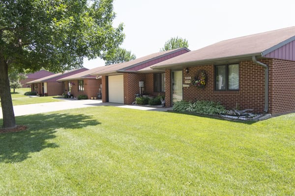 Row of brick homes at Sunrise Retirement Community with manicured lawns