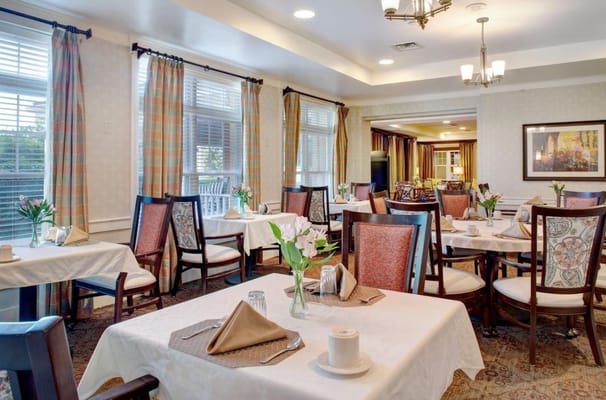 Bright and inviting dining room with tables set for residents