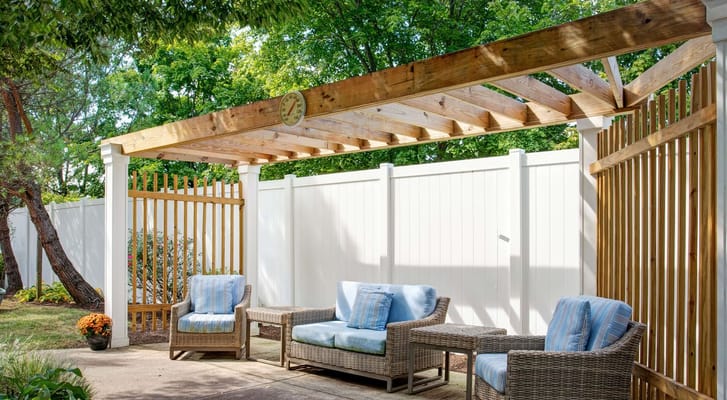 Outdoor seating area with comfortable chairs under a wooden pergola