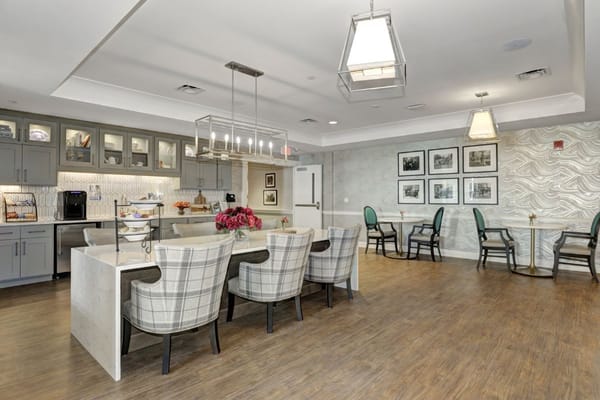 A modern kitchen and dining area with gray cabinets and comfortable seating.