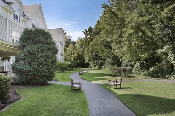 Walking path surrounded by greenery at assisted living facility