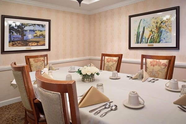 Dining room setup with floral decorations and paintings
