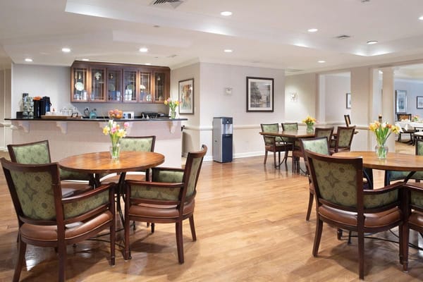 Dining area with tables and flowers at Sunrise of Woodcliff Lake