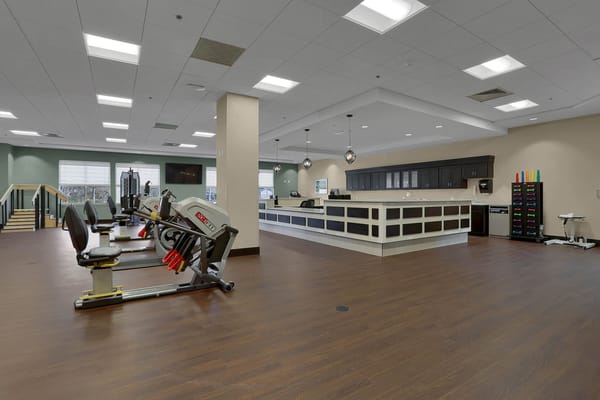 Well-equipped exercise area with fitness machines and a reception desk