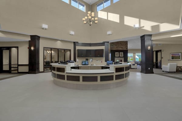 Lobby area with a reception desk at Sunterra Springs Independence.