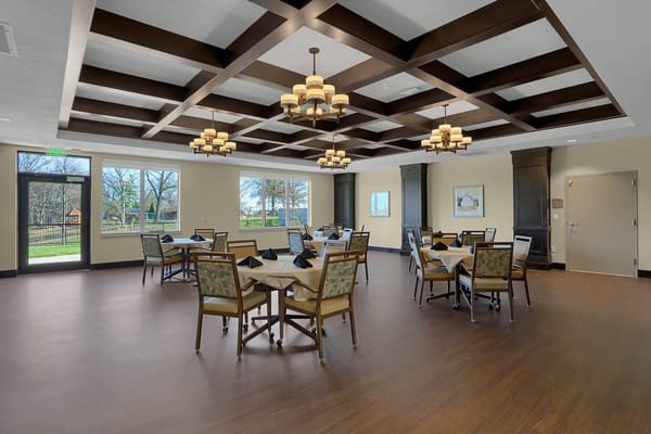 Spacious dining room with elegant decor and tables set for dining.