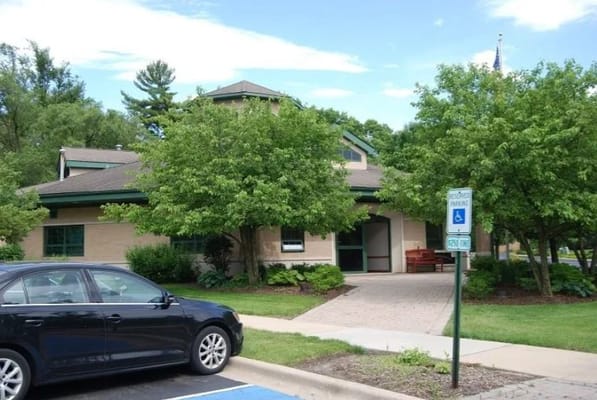 Front entrance of Tabor Hills senior living facility with trees and a parking area.