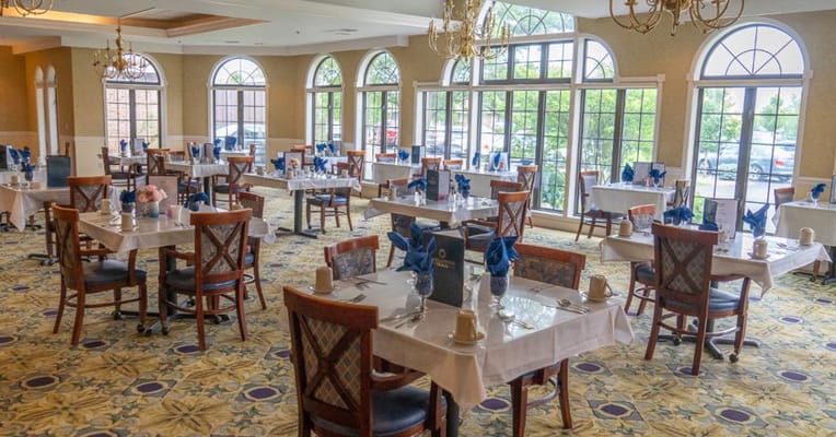 Interior view of a dining room with tables set for meals