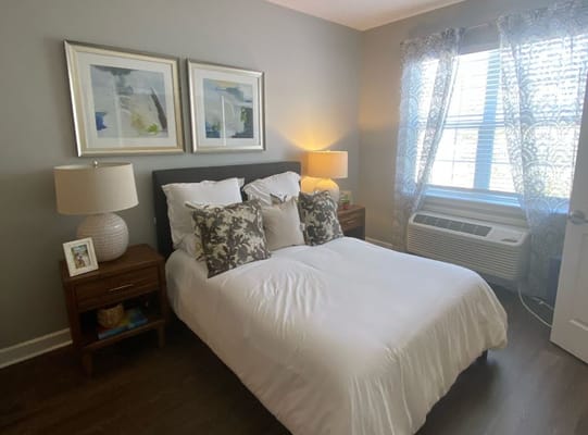 A well-furnished bedroom with a double bed, bedside tables, and window curtains.