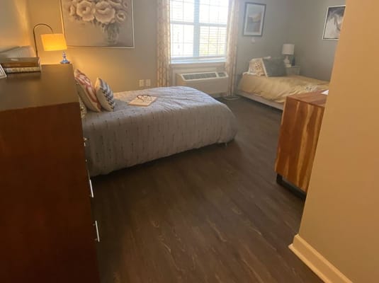 Interior view of a cozy bedroom with two beds and natural light