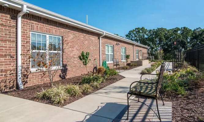 Exterior view of the garden area with benches and pathways at The Arbors at Westbrook Terrace.