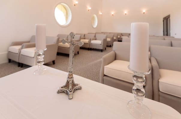 A silver cross and candles on a table in a chapel