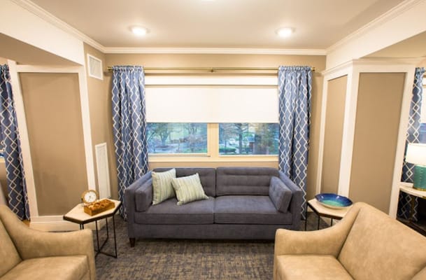 A comfortable living room with a blue couch and decorative cushions.