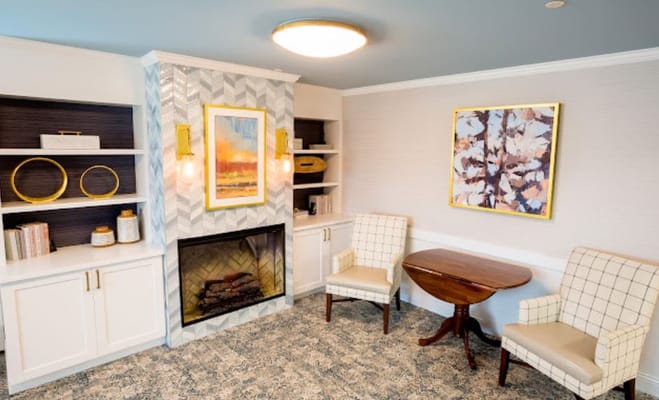 Comfortable living room with armchairs, a fireplace, and decorative wall art.