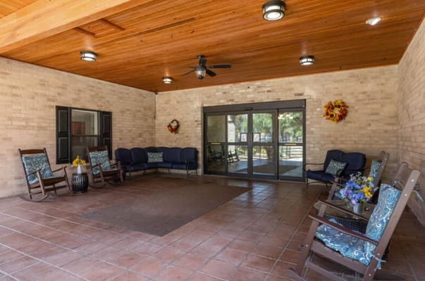 Outdoor seating area with rocking chairs and decorative flowers.