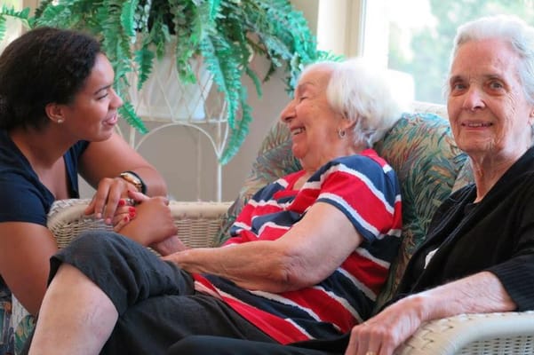 Three women sharing a joyful moment in a seating area.
