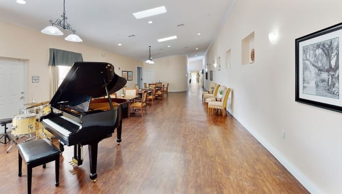 Black grand piano in a large, well-lit lobby area