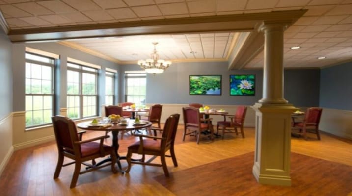Cozy dining area with tables and chairs, framed artwork, and natural light
